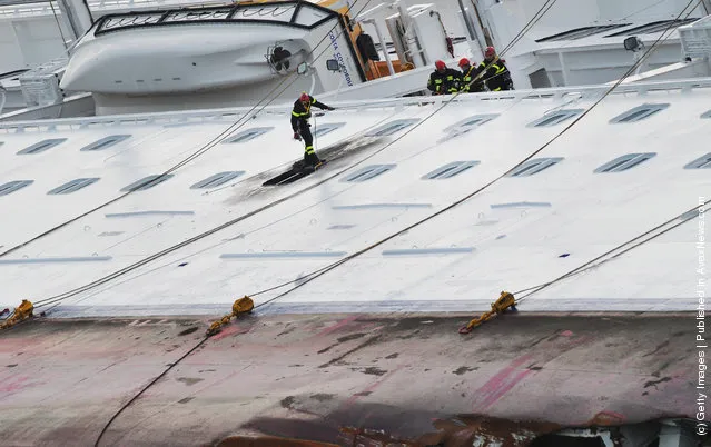 Rescuers work on the cruise ship Costa Concordia as lies stricken off the shore of the island of Giglio