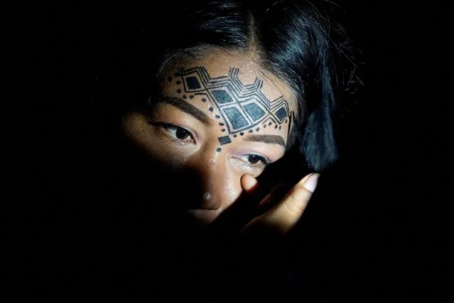 A woman with face paint attends a celebration during a meeting where leaders from indigenous communities in the Amazon basin demanded South American governments halt extractive industries that damage the rainforest, in Puyo, Ecuador on March 15, 2022. (Photo by Johanna Alarcon/Reuters)