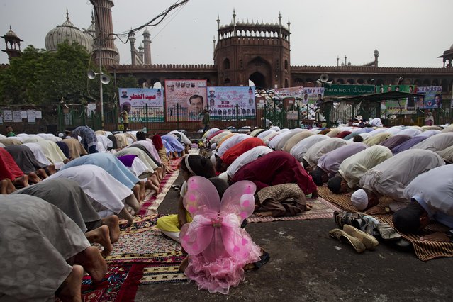 Indian Muslims offer Eid al-Fitr prayers outside the Jama Masjid mosque in New Delhi, India, Saturday, July 18, 2015. The day Eid ul-Fitr is celebrated depends on the sighting of the new moon and confusion often prevails when the Imams in one part of India spot the moon and others don't. It's not unusual for the festival to be celebrated on different days in different parts of India. (Photo by Bernat Armangue/AP Photo)