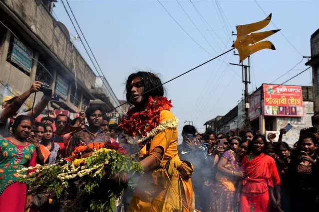 A devotee is seen with their mouth pierced by a vel spear (also known as a divine javelin) during the Vel Vel religious festival in West Bengal, India, on April 6, 2022. The spear is associated with the Hindu war god Murugan. (Photo credit should read Sukhomoy Sen/Eyepix Group/Future Publishing via Getty Images)