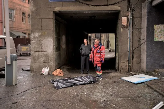 The body of a woman killed a Russian bombardment lies on a sidewalk in downtown Kharkiv, Ukraine, Sunday, April 17, 2022. (Photo by Felipe Dana/AP Photo)