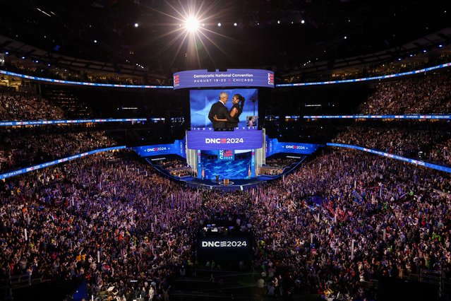 Former U.S. first lady Michelle Obama embraces her husband, former U.S. President Barack Obama, on stage before his speech during Day 2 of the Democratic National Convention (DNC) in Chicago, Illinois, U.S., August 20, 2024. (Photo by Mike Segar/Reuters)