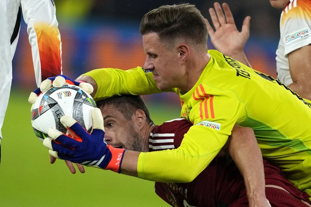 Germany's goalkeeper Marc-Andre Ter Stegen, centre, makes a save over Hungary's Barnabas Varga during the UEFA Nations League soccer match between Germany and Hungary at the Merkur Spiel-Arena in Dusseldorf, Germany, Saturday, September 7, 2024. (Photo by Michael Probst/AP Photo)