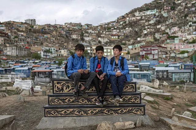 School boys chat amongst themselves as they visit the Kart-e-Sakhi cemetery in Kabul on April 24, 2022. (Photo by Wakil Kohsar/AFP Photo)