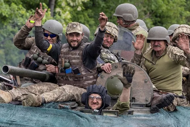 Ukrainian service members ride on top of a military vehicle, amid Russia's invasion of Ukraine, on the road between Kostiantynivka and Bakhmut, in the Donetsk region, Ukraine on May 28, 2022. (Photo by Carlos Barria/Reuters)