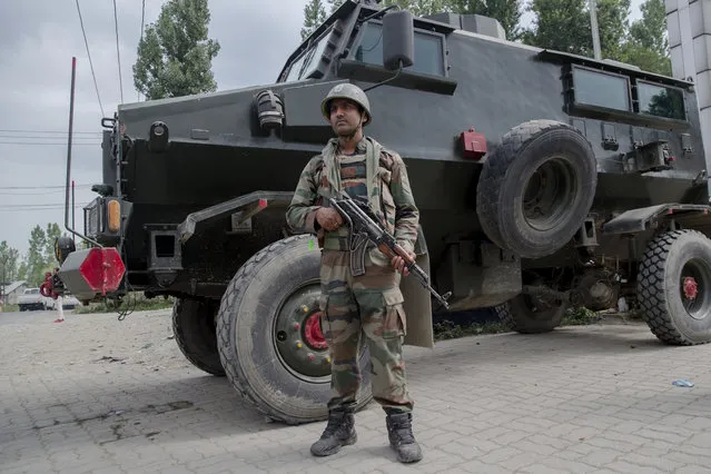 An Indian army soldier stands guard at site of shootout in Batengoo about 50 Kilometres (31.25 miles) south Srinagar, Indian controlled Kashmir, Tuesday, July 11, 2017. (Photo by Dar Yasin/AP Photo)