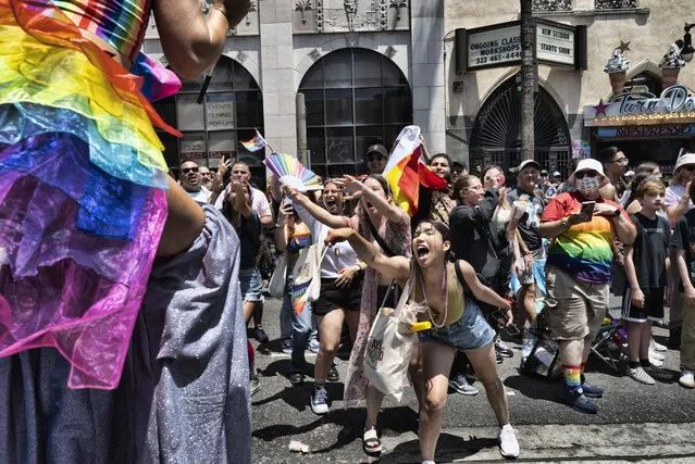 Spectators respond to a dancer along Hollywood Blvd. during the LA Pride Parade on Sunday, June 12, 2022 in the Hollywood section of Los Angeles. (Photo by Richard Vogel/AP Photo)