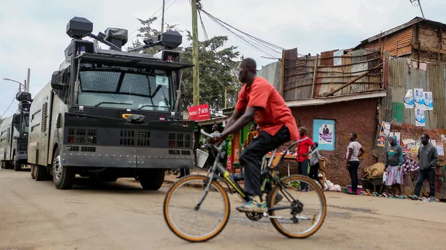 A man cycles past riot police water canons patrolling ahead of the presidential election in Kibera slums of Nairobi, Kenya, August 7, 2017. (Photo by Brian Inganga/Reuters)