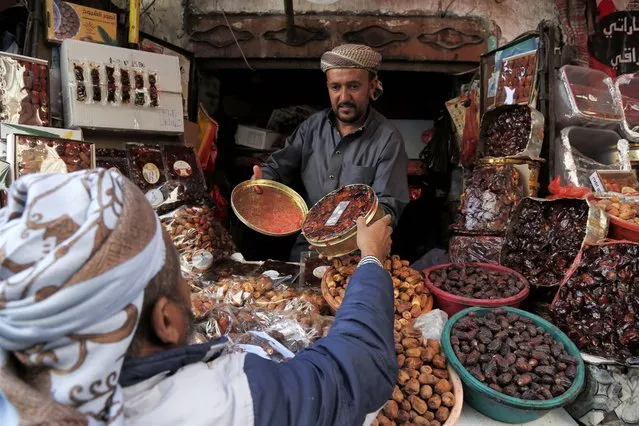 A man sells dates during Ramadan at a market in Sanaa, capital of Yemen, on April 9, 2022. (Photo by Xinhua News Agency/Rex Features/Shutterstock)