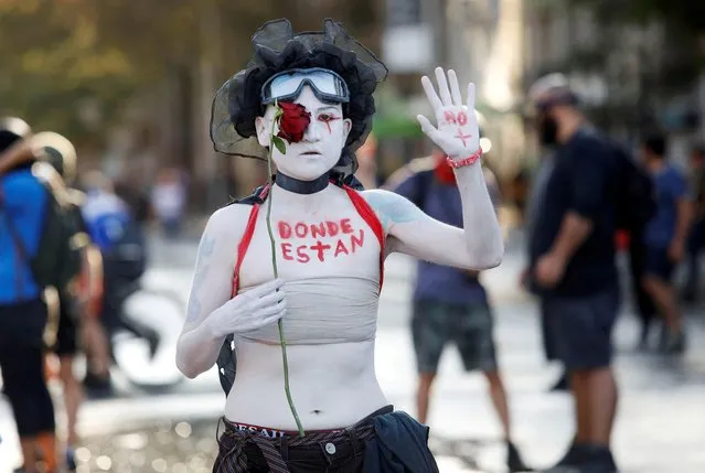 A demonstrator with words painted on her body reading “where are they?” takes part in a protest against Chile's government in Santiago, Chile on February 18, 2020. (Photo by Carlos Vera/Reuters)