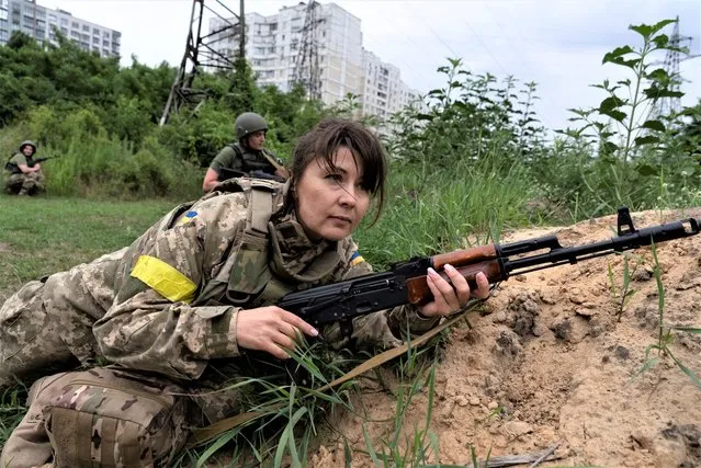 A woman holds a riffle as she attends a combat medic course training in Kyiv, Ukraine, Monday, July 11, 2022. Every day, up to 100 people attend the training. (Photo by Vasilisa Stepanenko/AP Photo)