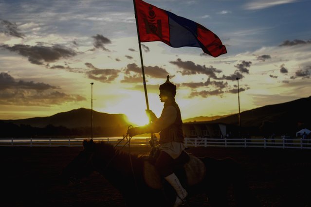 A horse rider holds a Mongolian flag during a traditional performance at a cultural event organized for the media and entourage following Pope Francis' visit to Mongolia, at the Mongolia Cultural Park, some 40 kilometers out of Ulaanbaatar, Mongolia, Friday, September 1, 2023. (Photo by Andrew Medichini/AP Photo)