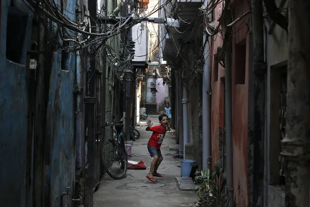 A boy reacts to the camera as he plays in an alley in New Delhi September 23, 2013. (Photo by Adnan Abidi/Reuters)