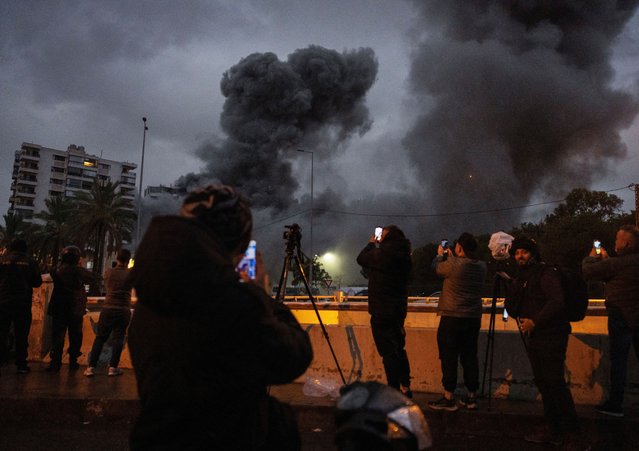 Members of the media and public record the moment of an Israeli strike on a building, amid the ongoing hostilities between Hezbollah and Israeli forces, in the Chiyah district of Beirut's southern suburbs, Lebanon, on November 25, 2024. (Photo by Adnan Abidi/Reuters)