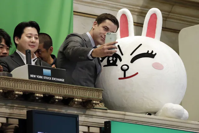 New York Stock Exchange President Tom Farley, center, takes a selfie with Line character Cony on the bell podium at the NYSE, Thursday, July 14, 2016. Line Chief Strategy & Marketing Officer Jun Masuda is at left, before his company's IFO. (Photo by Richard Drew/AP Photo)
