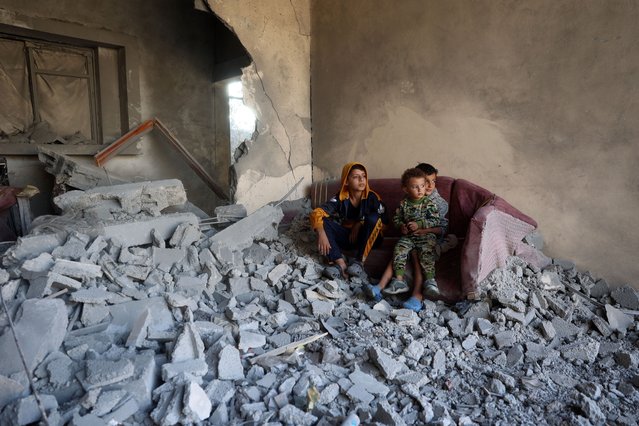 Children sit on a couch amid the destruction following an Israeli strike in the Nuseirat refugee camp in the central Gaza Strip on November 7, 2024, amid the ongoing war between Israel and Palestinian Hamas militants. (Photo by Eyad Baba/AFP Photo)