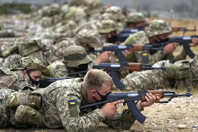 Ukrainian volunteer military recruits take part in an urban battle exercise whilst being trained by British Armed Forces at a military base in Southern England, Monday, August 15, 2022. MOD and British Army as the UK Armed Forces continue to deliver international training of Ukrainian Armed Forces recruits in the United Kingdom.(Photo by Frank Augstein/AP Photo)