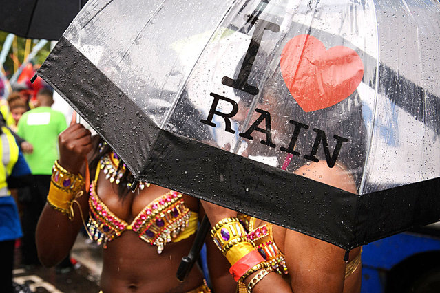 A performer carries an “I Love Rain” umbrella during the parade on the second day of the Notting Hill Carnival in west London on August 25, 2014. (Photo by Leon Neal/AFP Photo)