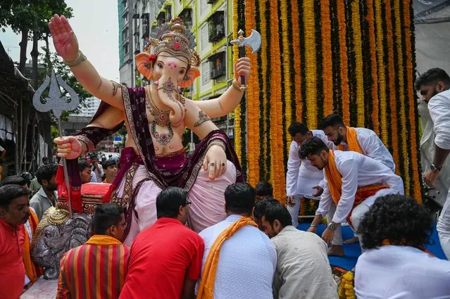 Hindu devotees transport an idol of the elephant-headed Hindu deity Ganesha during a procession on the first day of ten-day “Ganesh Chaturthi” festival in Mumbai on August 31, 2022. (Photo by Punit Paranjpe/AFP Photo)