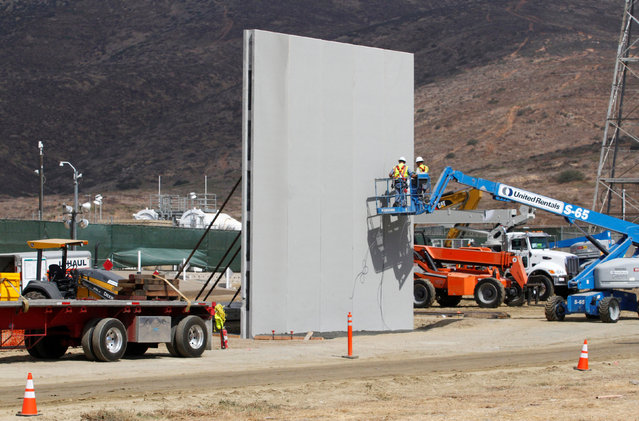 People work in San Diego, California, U.S., at the construction site of prototypes for U.S. President Donald Trump's border wall with Mexico, in this picture taken from the Mexican side of the border in Tijuana, Mexico October 3, 2017. (Photo by Jorge Duenes/Reuters)
