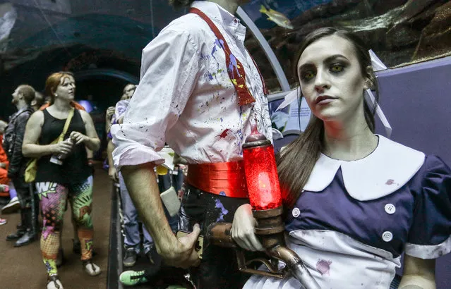 In this Saturday, September 5, 2015, photo, a woman dressed as Little Sister, a character from the popular “BioShock” video game, attends a private party held at the Georgia Aquarium as part of Dragon Con in Atlanta. The convention draws fans from around the country to take part in sci-fi and fantasy costume contests, a massive parade through downtown Atlanta and educational seminars about science and costume making. (Photo by Ron Harris/AP Photo)