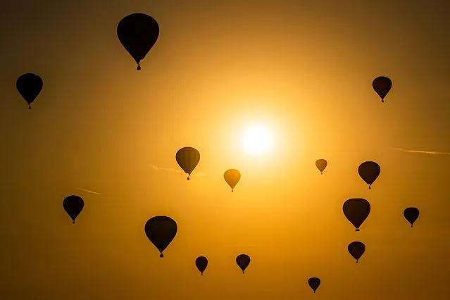 A hot air balloons pass by the sun as they fly over North Somerset in early morning sunlight, during the mass ascent the Bristol International Balloon Fiesta 2022 on Sunday, August 14, 2022. (Photo by Ben Birchall/PA Images via Getty Images)