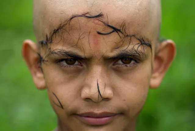 Sabin Parajuli, student of “Bhagwat Sanyash Ashram and Gurkul”, looks on after shaving his head during a full moon day in Gurukul’s premise in Kathmandu, Nepal, 27 July 2017. Once a month, in the auspicious day of full moon, the students must shave their head since they believe that by shaving the hair they are free from the sins. A temple in Nepal’s capital Kathmandu is home to one of the world’s oldest Sanskrit schools. Located within Pashupati Temple and founded in 2040 BS (Nepali Year Calendar), 34 years ago, Shree Bhagwat Sanyash Ashram and Gurukul School and hostel is funded by the donations of Hindu followers. The school was established to practice and preserve the Sanskrit Dharma-shastra. Sanskrit is the main holy language in Hinduism and Dharma-shastras are Hindu scriptures teaching the rules of social behavior. (Photo by Narendra Shrestha/EPA/EFE)