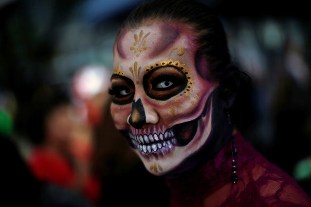 A woman dressed up as “Catrina”, a Mexican character also known as “The Elegant Death”, takes part in a Catrinas parade in Mexico City, Mexico on October 22, 2017. (Photo by Carlos Jasso/Reuters)