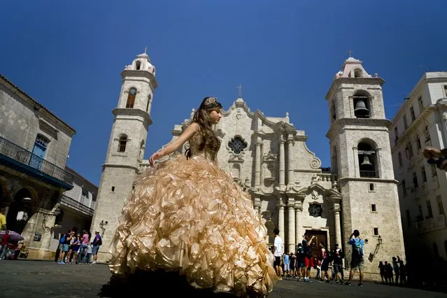 In this March 14, 2016 file photo, a “quinceanera” poses during her photo session in front of the cathedral as tourists line up to enter the building, in Havana, Cuba. Scheduled commercial airline service to Havana from 10 American cities won tentative government approval Thursday, July 7, 2016, advancing President Barack Obama's effort to normalize relations with Cuba. (Photo by Ramon Espinosa/AP Photo)