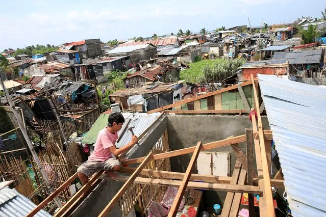A man fixes the roof of his home after a Tornado and torrential rains downpour brought by the monsoon rains battered a residential area in Baseco, Tondo city, metro Manila, Philippines August 15, 2016. (Photo by Romeo Ranoco/Reuters)