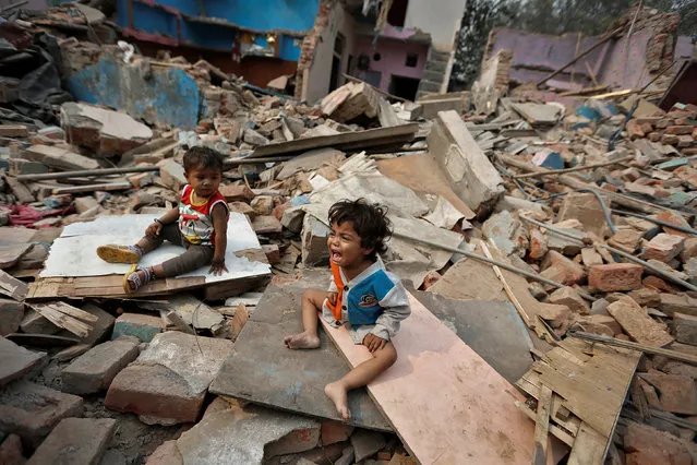 A child cries amid the rubble of their home in a slum which was razed to the ground by local authorities in a bid to relocate the residents, Delhi,, November 2, 2017. (Photo by Cathal McNaughton/Reuters)