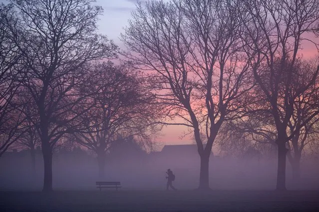 A pedestrian walks in a mist-covered park in Ilford, East London, in the morning, Wednesday, 12 January 2022, as the temperature has dropped. (Photo by Akira Suemori/Rex Features/Shutterstock)