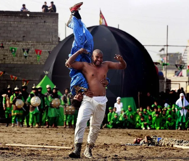 Shiite Muslims re-enact the seventh century battle of Karbala during the climax of the festival of Ashoura in the Shiite neighborhood of Sadr City in Baghdad, Iraq, November 25, 2012. (Photo by Hadi Mizban/Associated Press)