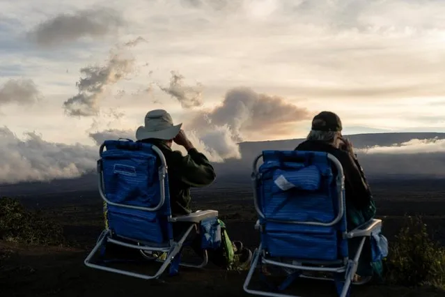 People sit in chairs while observing the eruption of the Mauna Loa Volcano in Hawaii, U.S. December 1, 2022. (Photo by Go Nakamura/Reuters)