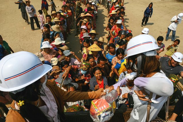 People line up for food aid being distributed in Sagaing on April 3, 2025, following the March 28 earthquake. The shallow 7.7-magnitude earthquake on March 28 flattened buildings across Myanmar, killing more than 3,000 people and making thousands more homeless. (Photo by Sai Aung Main/AFP Photo)