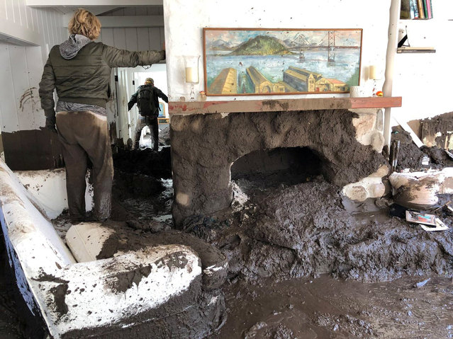 Family members inspect the inside of a home covered in mud following the mudslides in Montecito, California, U.S., in this photo provided by the Santa Barbara County Fire Department, January 10, 2018. (Photo by Mike Eliason/Reuters/Santa Barbara County Fire Department)