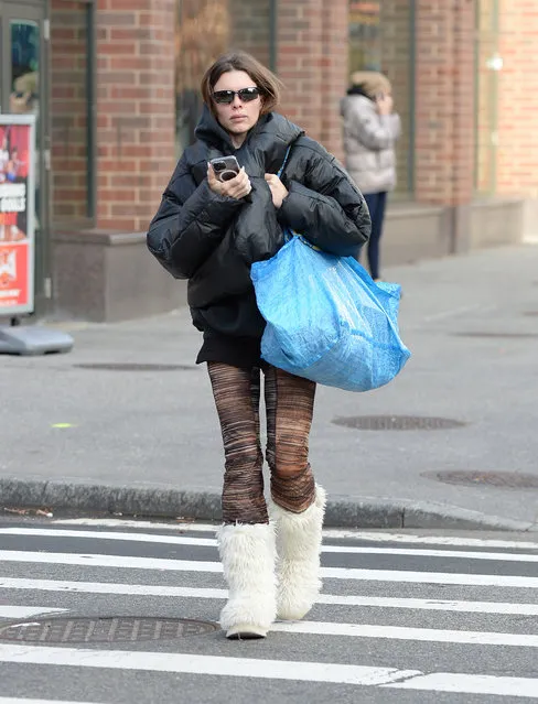 Julia Fox is spotted on a stroll in New York City on December 18, 2022. The American actress and model carried an Ikea bag and wore a black puffer jacket, patterned leggings, and white furry boots. (Photo by The Image Direct)