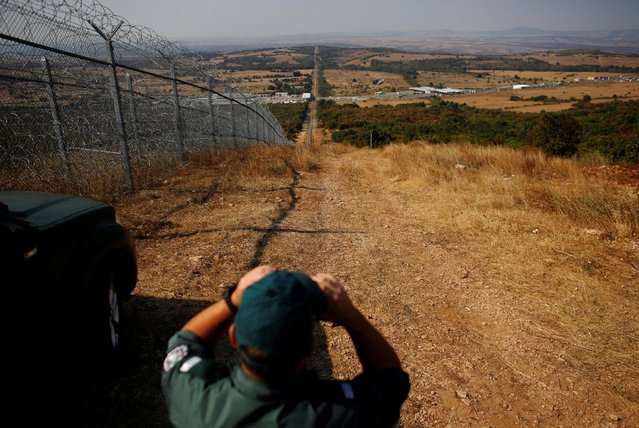 A Bulgarian border policeman monitors near the barbed wire fence constructed on the Bulgarian-Turkish border, near Lesovo, Bulgaria September 14, 2016. (Photo by Stoyan Nenov/Reuters)