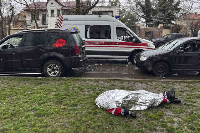 In this photo provided by the Odesa City Administration, the dead body of a medic employee killed during a Russian attack, lies on the ground in Odesa, Ukraine, Friday, March 15, 2024. First responders who arrived at the scene of a Russian missile attack on homes in the southern Ukrainian city of Odesa on Friday were themselves struck by a second missile, officials said. A paramedic and an emergency service worker were among the people killed. (Photo by Odesa City Administration via AP Photo)