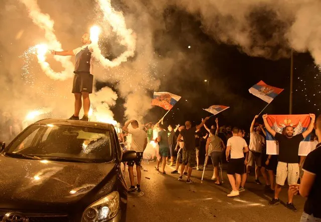 Supporters of opposition groups celebrate after poll closed in Montenegro's parliamentary elections in Podgorica, Montenegro, early Monday, August 31, 2020. Montenegro's pro-Serb and Russian opposition groups claimed victory against the ruling pro-Western party in a tense parliamentary election that could see a change in the course of the small Balkan state. (Photo by Risto Bozovic/AP Photo)