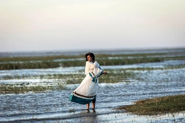 A woman looks on during the celebration of timkat, the baptism of Jesus by John the Baptist on lake Ziway, also known as lake Dembel, Ethiopia, on January 18, 2023. (Photo by Amanuel Sileshi/AFP Photo)