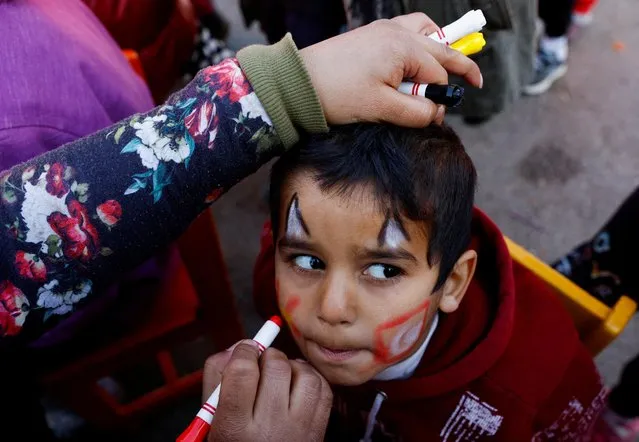A woman paints a child's face during an activity to entertain and support mental health of children affected by the deadly earthquake in Osmaniye, Turkey on February 16, 2023. (Photo by Suhaib Salem/Reuters)