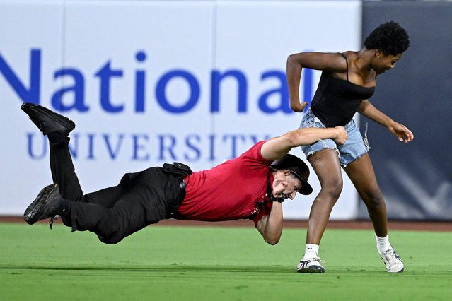 A security guard tackles a fan who ran on the field during the ninth inning of a game between the San Francisco Giants and the San Diego Padres at Petco Park in San Diego, California on August 19, 2025. (Photo by Denis Poroy/Reuters)