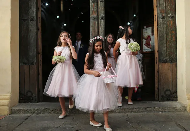 A flower girl blows bubbles as the wedding party departs a historic church following the marriage ceremony October 1, 2016 in Bogota, Colombia. Colombians will cast their ballots on October 2 in a final referendum on a peace accord to end the 52-year-old guerrilla war between the FARC and the state, the longest-running armed conflict in the Americas which has left 220,000 dead. The plan calls for a disarmament and re-integration of most of the estimated 7,000 FARC fighters. (Photo by Mario Tama/Getty Images)