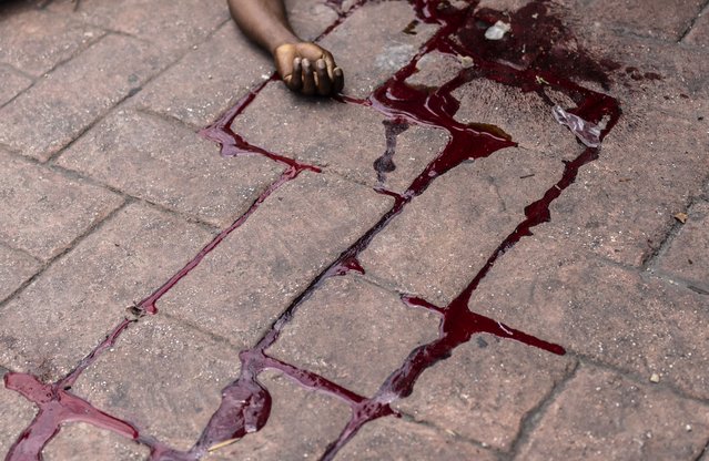 The body of a man shot dead lies in a pool of blood in the Petion-Ville neighborhood of Port-au-Prince, Haiti, May 3, 2024. (Photo by Ramon Espinosa/AP Photo)