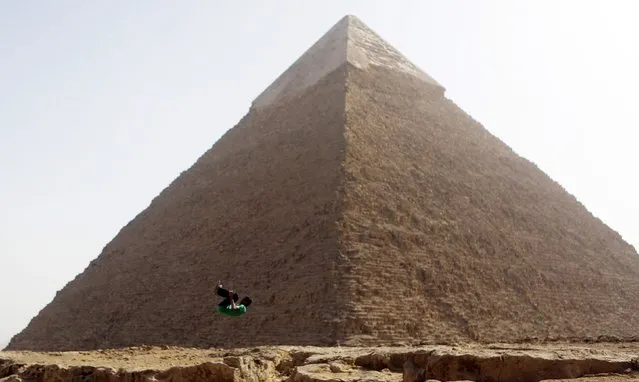 Faisel,16, a member of Egyptian parkour group “EGY PK”, practices a jump in front of the Pyramid of Khufu, the largest of the Great Pyramids of Giza, on the outskirts of Cairo, December 9, 2014. EGY PK, one of the first parkour groups in Egypt, are training to ahead of performing publicly during the year-end Christamas celebrations, to promote tourism in Egypt. (Photo by Amr Abdallah Dalsh/Reuters)