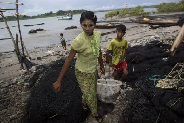 A girl and boy carry a basket of fish in Kyaukpyu township, Rakhine state, Myanmar October 6, 2015. (Photo by Soe Zeya Tun/Reuters)