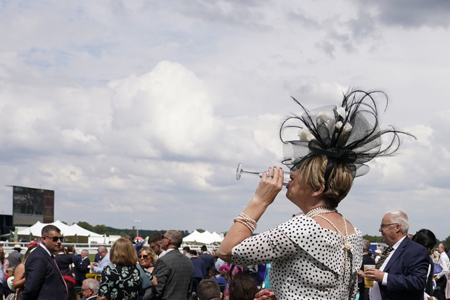 A racegoers take a drink between races in the public enclosure on the first day of the Royal Ascot horse race meeting at Ascot, England, Tuesday, June 18, 2024. (Photo by Alberto Pezzali/AP Photo)