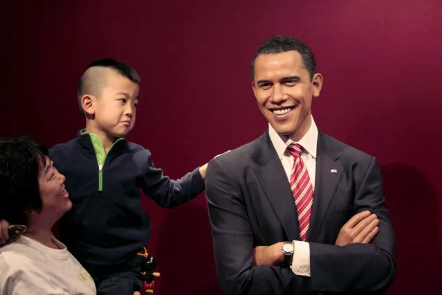 People pose next to a wax figure of U.S. President Barack Obama at Madame Tussauds Wax Museum in Shanghai, November 12, 2009. (Photo by Aly Song/Reuters)