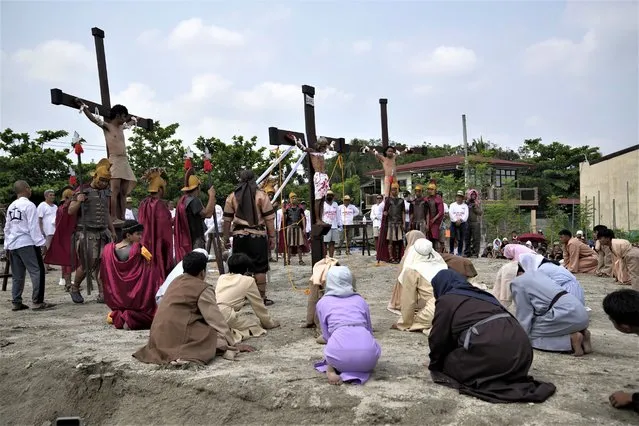 Wilfredo Salvador, center, and two actors stay on crosses during a reenactment of Jesus Christ's sufferings as part of Good Friday rituals April 7, 2023 in the village of San Pedro, Cutud, Pampanga province, northern Philippines. The real-life crucifixions, a gory Good Friday tradition that is rejected by the Catholic church, resumes in this farming village after a three-year pause due to the coronavirus pandemic.(Photo by Aaron Favila/AP Photo)